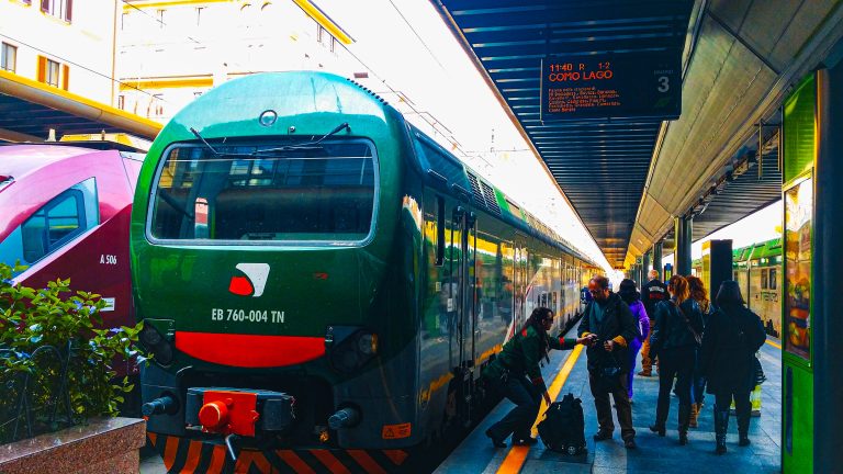 Train in Milano Central station with a group of people standing nearby