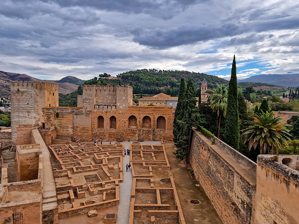 5 travel planning mistakes beginners make 2 Stone courtyard inside the Alhambra in Granada, with visible foundations and low walls outlining former rooms