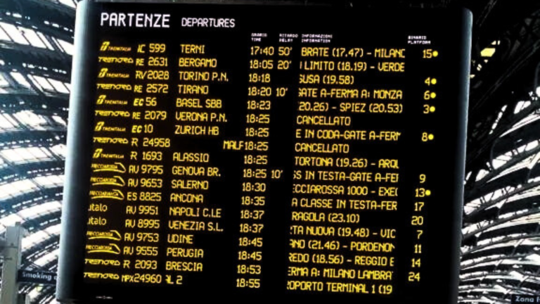Digital train departure board showing multiple delayed and cancelled trains at a station.