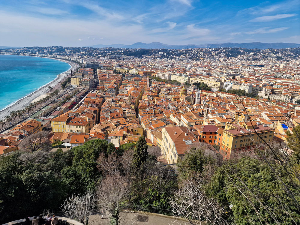 5 best cities in Europe for a first-time traveller 4 A panoramic view of Nice showing terracotta rooftops, the coastline, and the blue waters of the Mediterranean Sea.