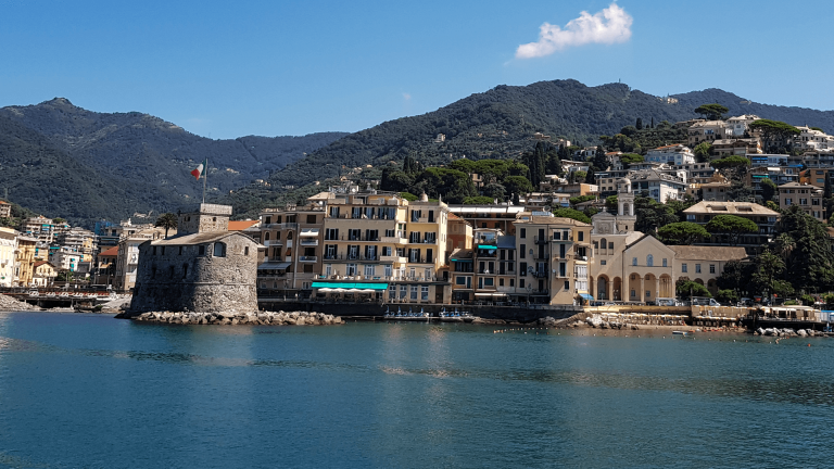 Rapallo’s small seaside castle and colourful houses photographed from the water.